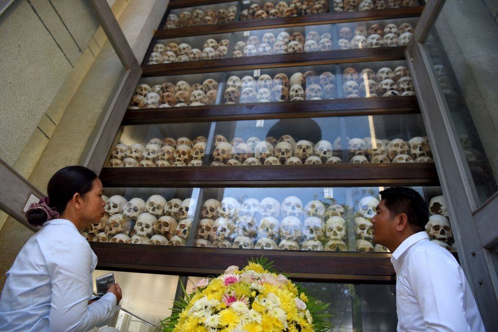 #1 People looking at skulls displayed in a stupa during the annual ‘Day of Remembrance’ at the Choeung Ek killing fields memorial in Phnom Penh