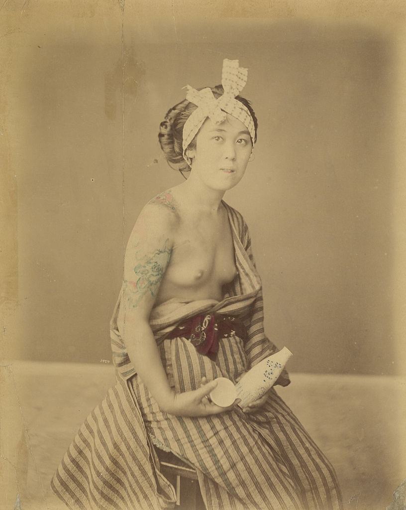 #5 A young Japanese woman displays her tattoos, circa 1880