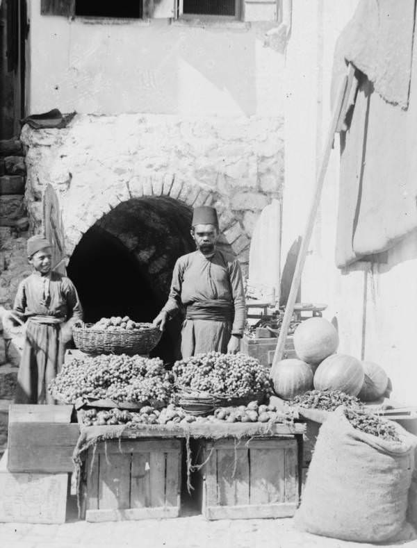 #34 A fruit vendor displays his goods, Circa 1900-1920