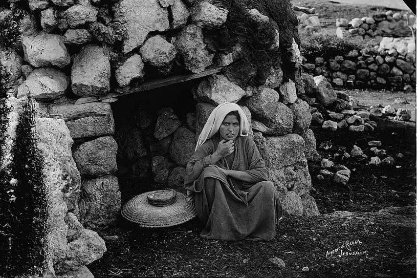 #47 A woman sits in front of the village oven, Circa 1898-1914