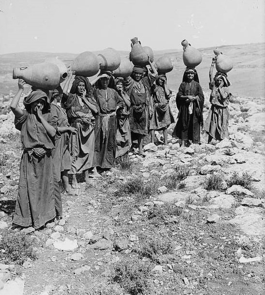 #52 A group of women carrying water jars on their heads, Circa 1900-1920