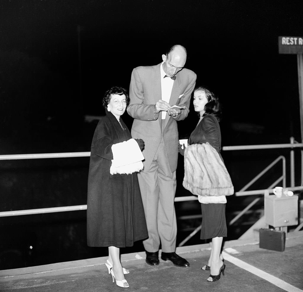 #22 Joan Bradshaw poses with a tall man in Los Angeles, 1957