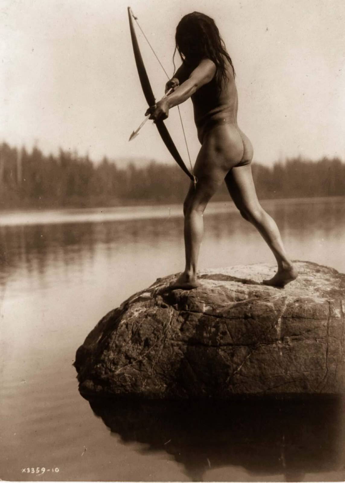 #32 A Nootka man aims a bow and arrow. 1910.