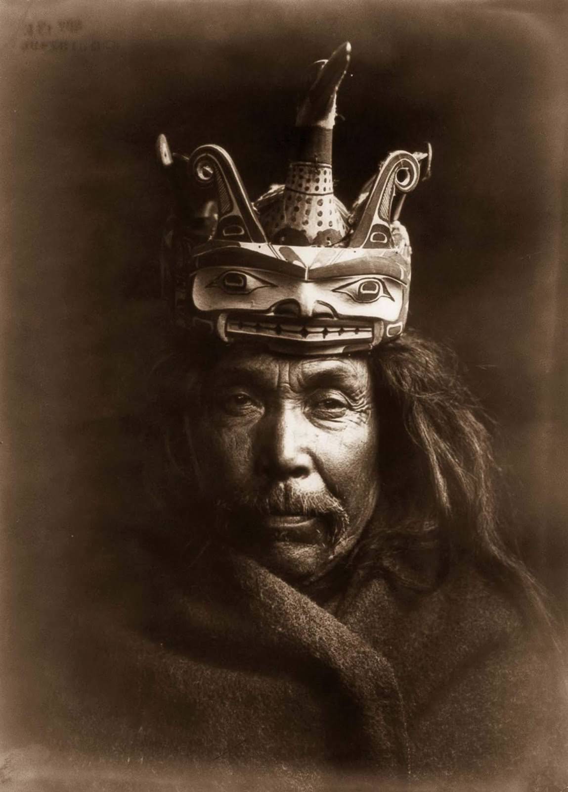 #36 A Kwakiutl man wearing a mask depicting a man transforming into a loon. 1914.
