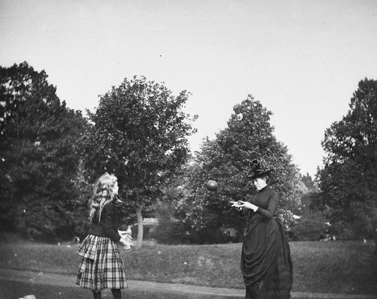 #13 Zelma Levison and her aunt Jo Grimwood throw a ball back and forth on a lawn in Prospect Park.July 20, 1886