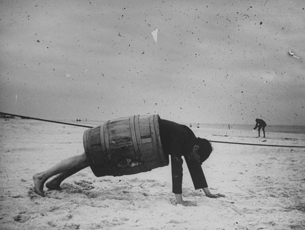 #19 A man in a barrel does a push up at the beach.Sept. 8, 1897