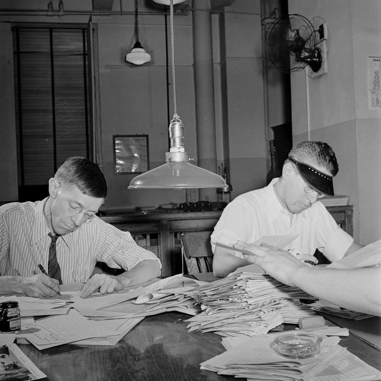 Copyreaders at the foreign desk in the newsroom. In the foreground, the foreign editor discards a story by “spiking” it.