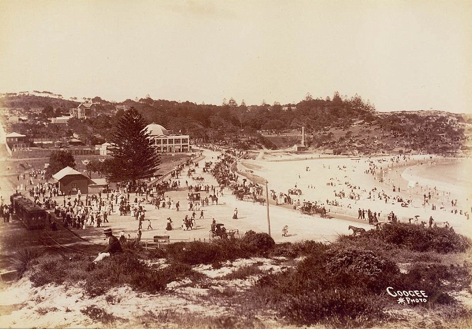 #38 Coogee Beach circa 1905 shows a tram line running down the hill to the sandy beachfront, and Coogee Pavilion in the distance at one end of the beach