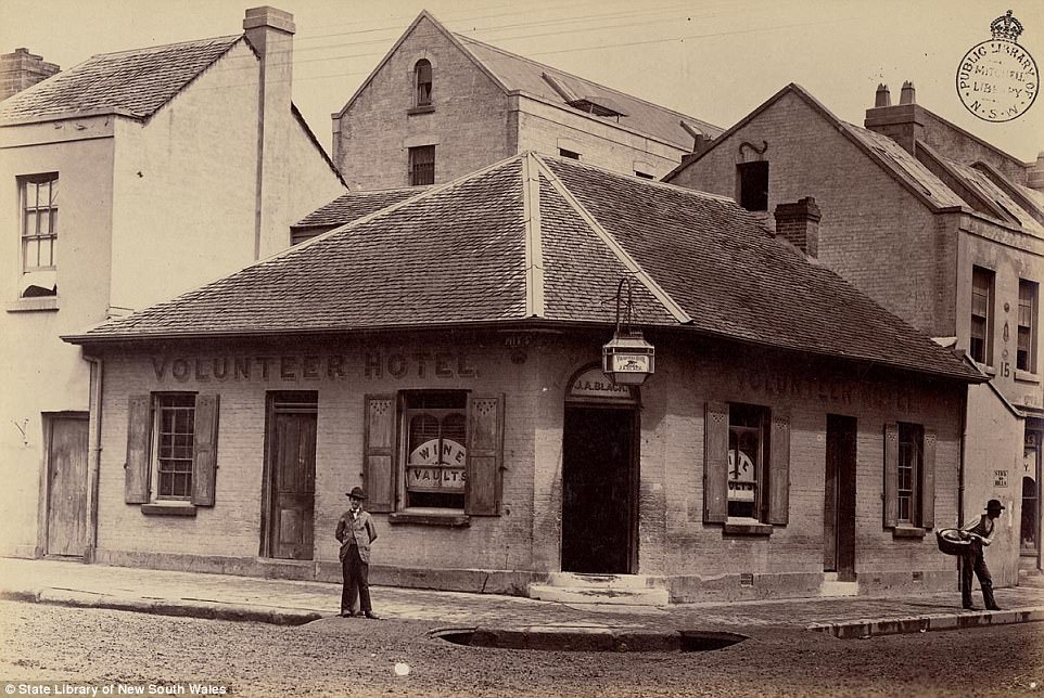 #20 Two men, one holding a basket, are seen standing outside the brick Volunteer Hotel on Pitt Street in Sydney, circa 1870