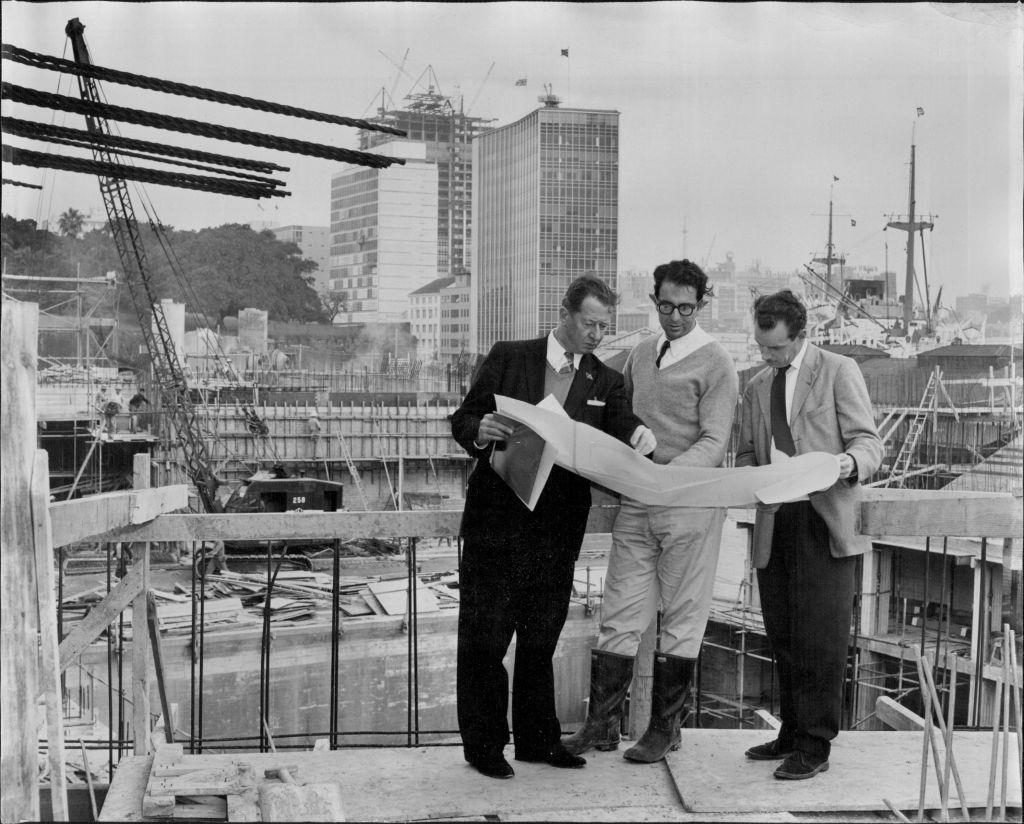 #10 Left to right: R. J. Thomson, secretary of the Sydney Opera House Executive Committee – Mr. A. Levy, resident engineer – and Mr. O. Skipper-Nielsen, President architect with the plan of the major hall stage which is shown behind them, 1961