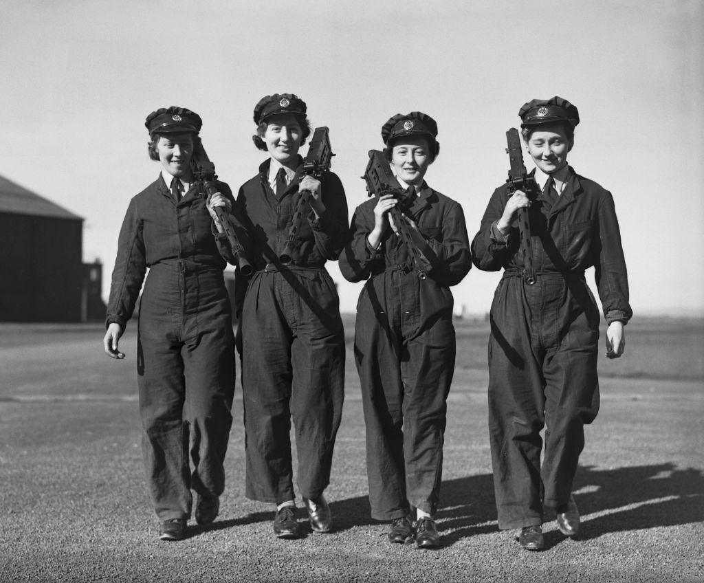 Members of the Women’s Auxiliary Air Force (WAAF) carrying aircraft machine guns