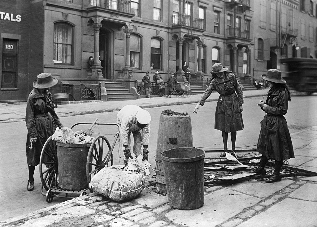 #54 Girl Scouts taking notes on methods of a New York street cleaner, 1930s.