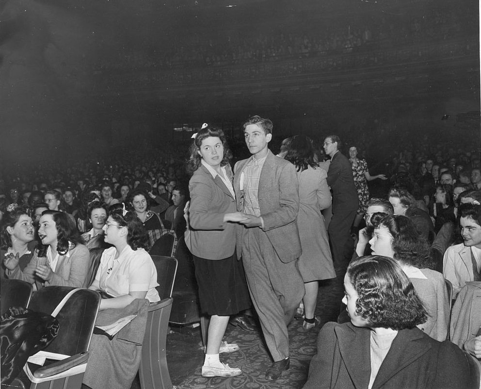 #55 Teenage couple dancing in the aisle of New York’s Paramount Theater, 1930s.