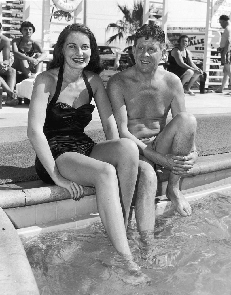 #57 American actor and singer Rudy Vallee and his wife, Eleanor Norris, relaxing poolside at the El Rancho Vegas resort, 1950.