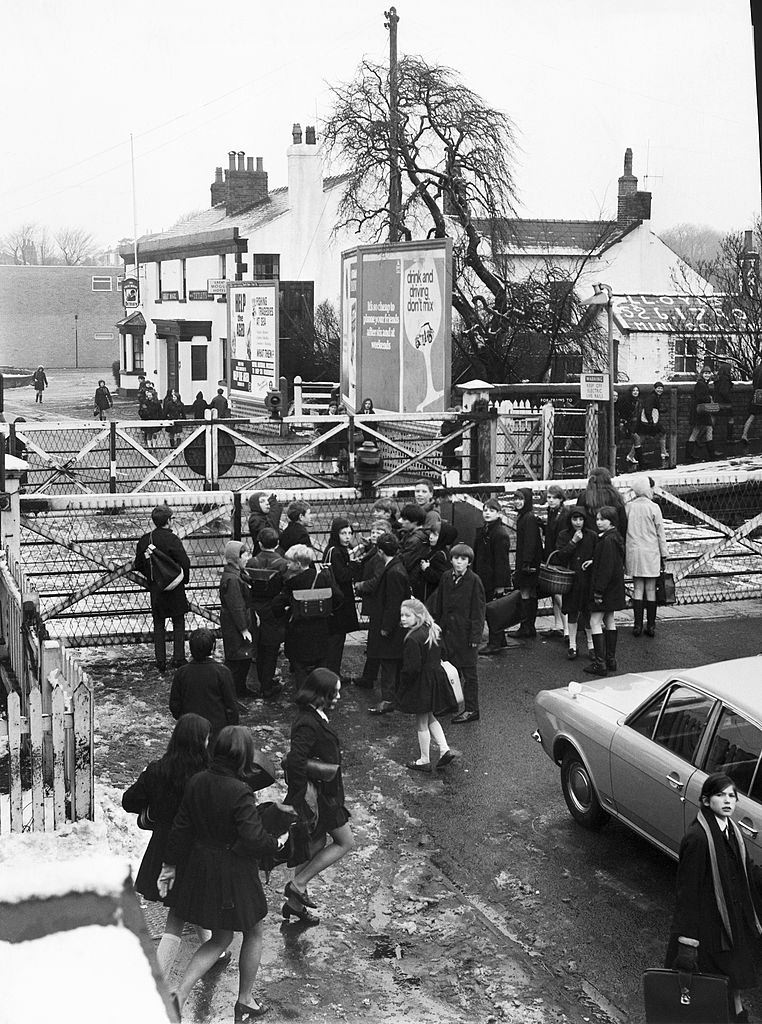 #22 Children on the way home from school wait to cross over the railway, 1970s.