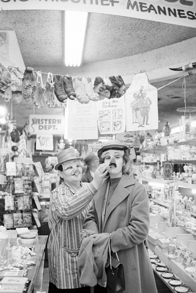 #14 Jane Fonda trying on a mask in a drugstore.