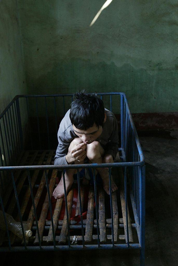 #16 Truong Tan Thong, a 25-year-old soldier’s son who has spent most of his life in a playpen. He is a victim of the Agent Orange legacy, 20 April 2005