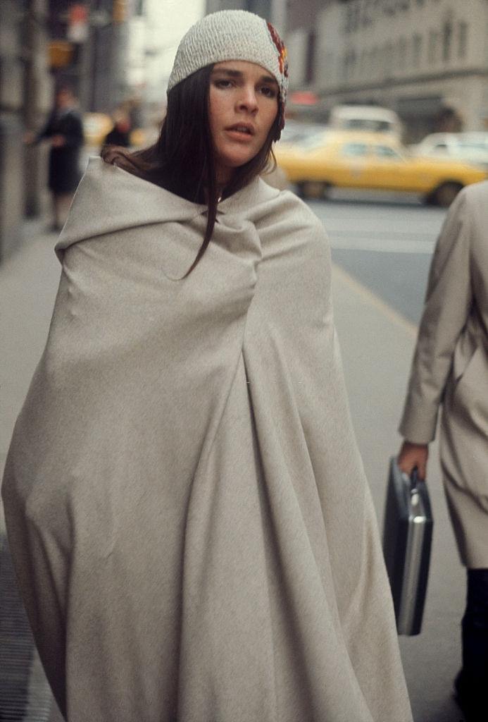 #25 Ali MacGraw wrapped in a blanket walking on the street, 1970.
