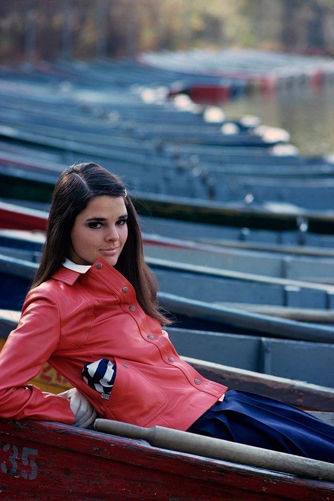 #10 Ali MacGraw in a orange patent leather jacket, polo shirt and navy wool box-pleated skirt, Glamour, 1967.