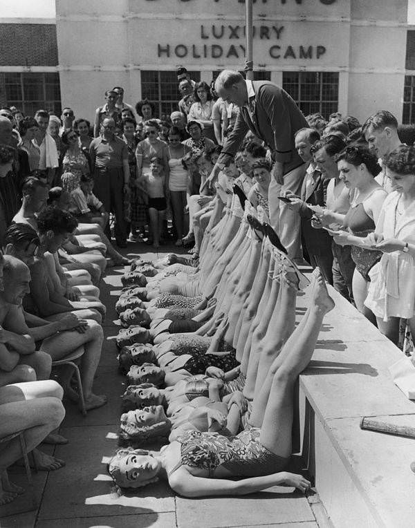 Beauty contestants are judged solely on their figures, thanks to the introduction of papier mache masks, at Butlin’s holiday camp in Clacton-on-Sea, England, 1952