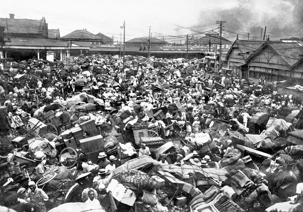 #35 A plaza in front of Tokyo’s Ueno Station is inundated with people carting furniture and other belongings and trying to flee after the Kanto Earthquake.