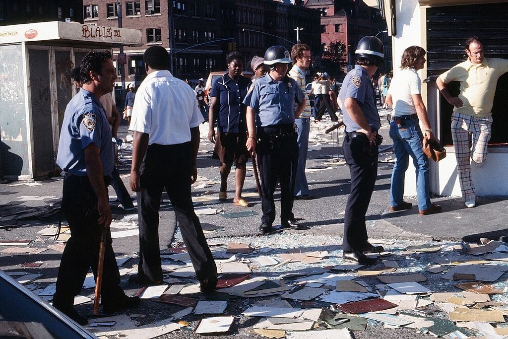 #43 People fill up buckets and bottles from an opened fire hydrant after the blackout, New York City, 1977.