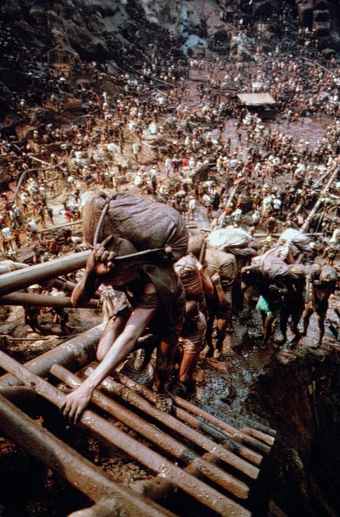 #12 Hundreds of workers carrying bags from the pit up the slopes in Serra Pelada Gold Mine, Brazil, 1980s.