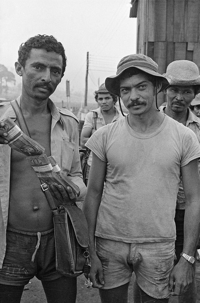 #13 Antonio Chavez displays money received at local bank after cashing in gold.