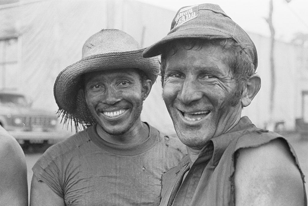 The mud on their faces can’t hide the smiles of two gold miners seeking pay dirt in the Amazon.