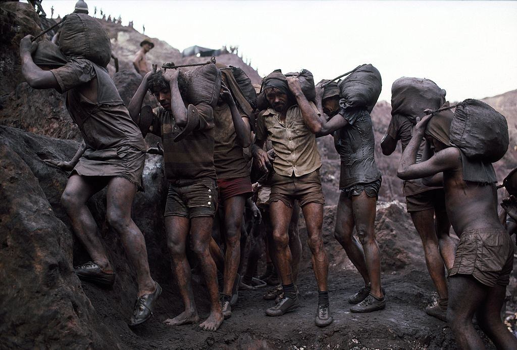 #15 Mine workers haul out 40-pound bags of ore from their owners mining claims July 15, 1985 in Serra Pelada, Brazil.