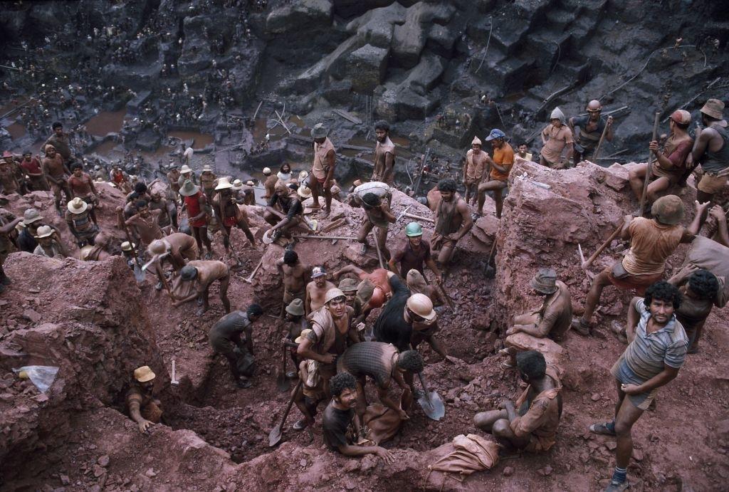 #16 Mine workers use picks and shovels to break up ore in single plot claims of 6.6 feet by 9.8 feet in Serra Pelada, Brazil.