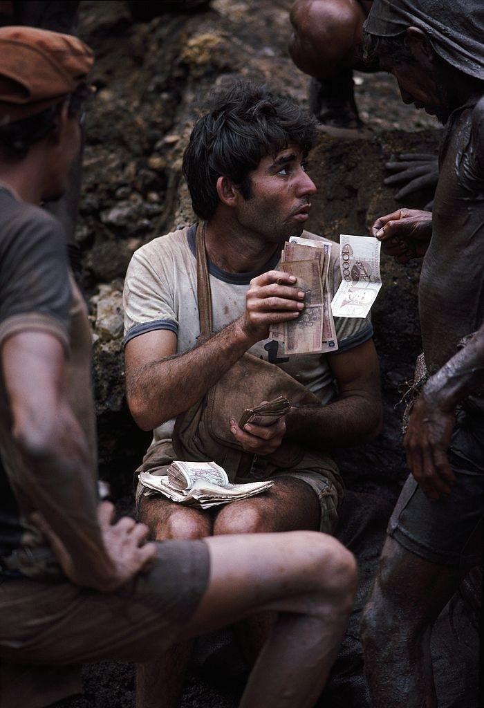 #21 A paymaster hands over wages July 15, 1985 to mine workers.