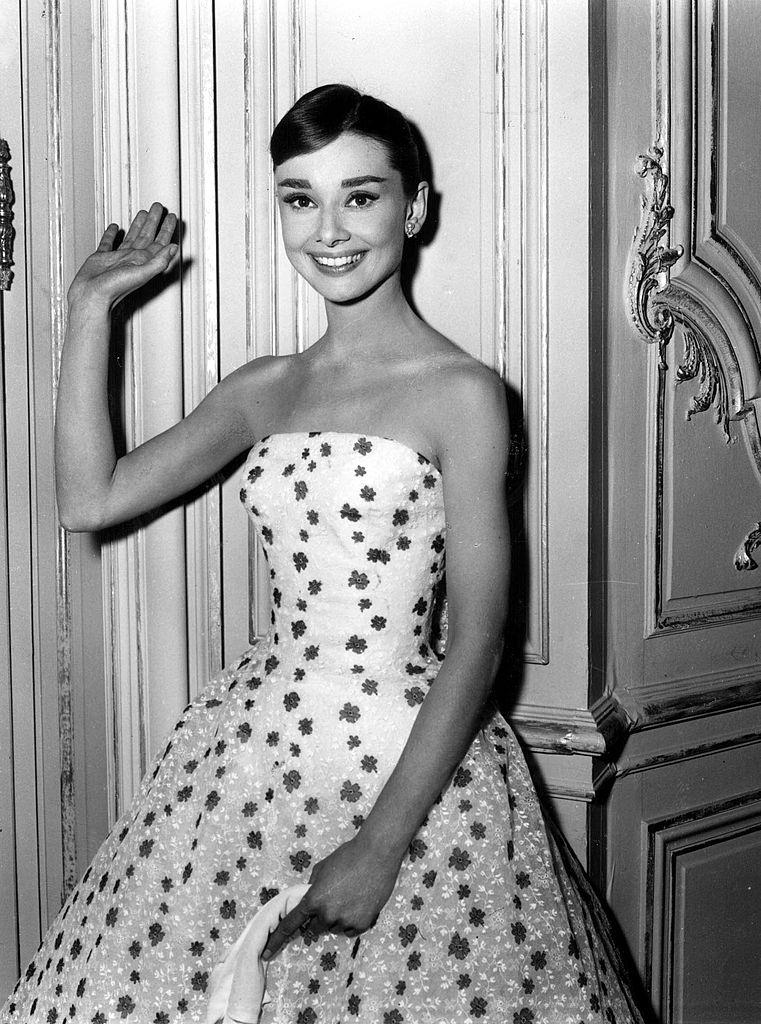 #46 Audrey Hepburn waves at the camera, 1950s.