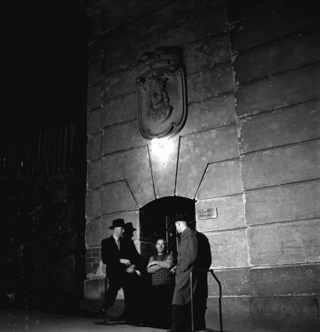 #27 Three men outside the entrance to the bachelor hotel Kronoberg, 54 Bergsgatan, Kungsholmen.
