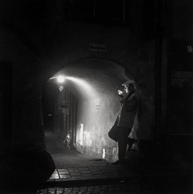 #29 Man lighting a cigarette at Bredgränd, Gamla stan.