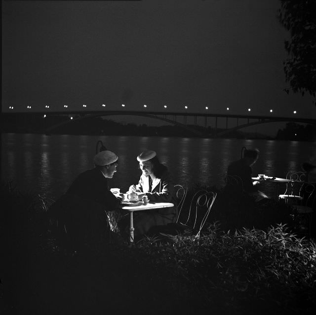 #2 Two women sit at a table on an outdoor terrace in evening lighting, North Mälarstrand.