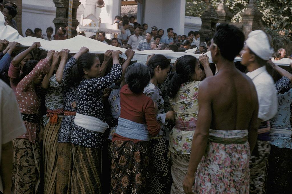 #13 People holding a long white piece of clothe during a cremation, Bali, 1958.