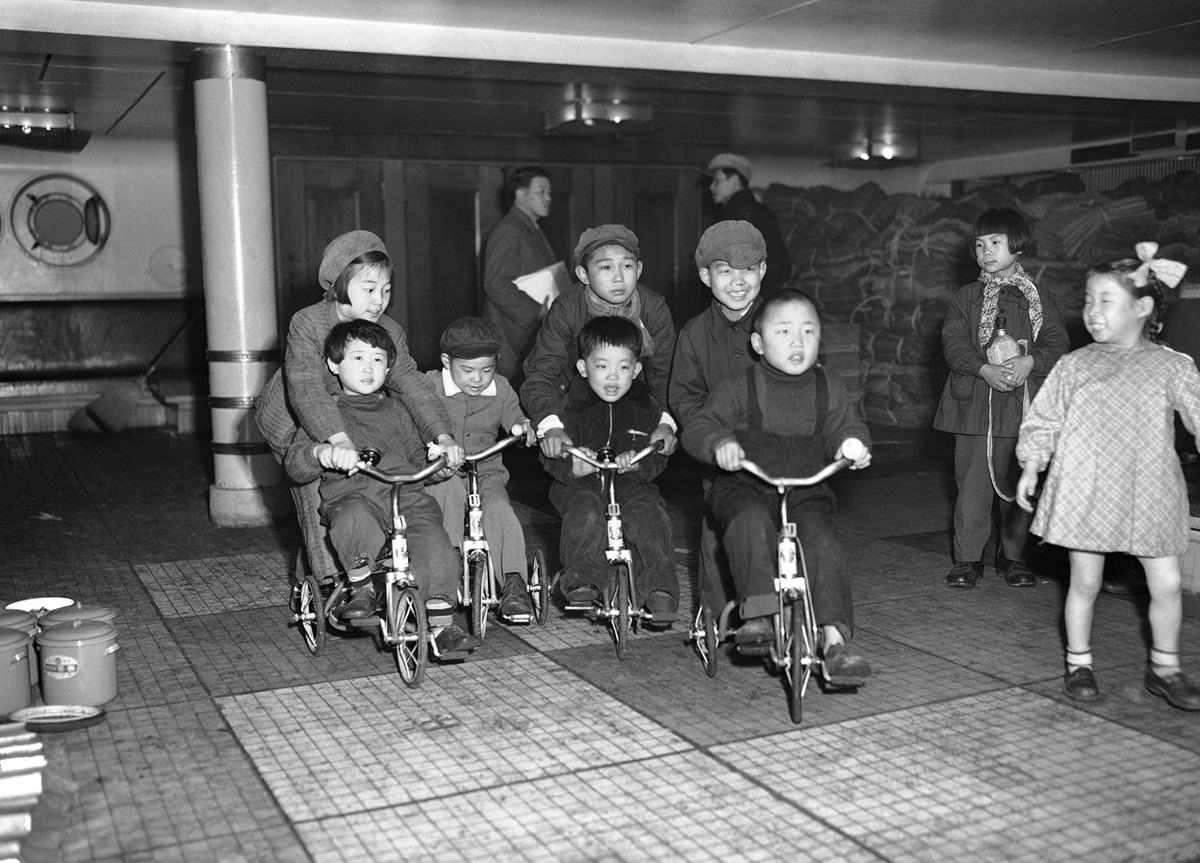 #14 Children of repatriated families scoot around the deck of the Koan Maru as their parents prepare to disembark at Maizuru Bay, Japan, on March 24, 1953.