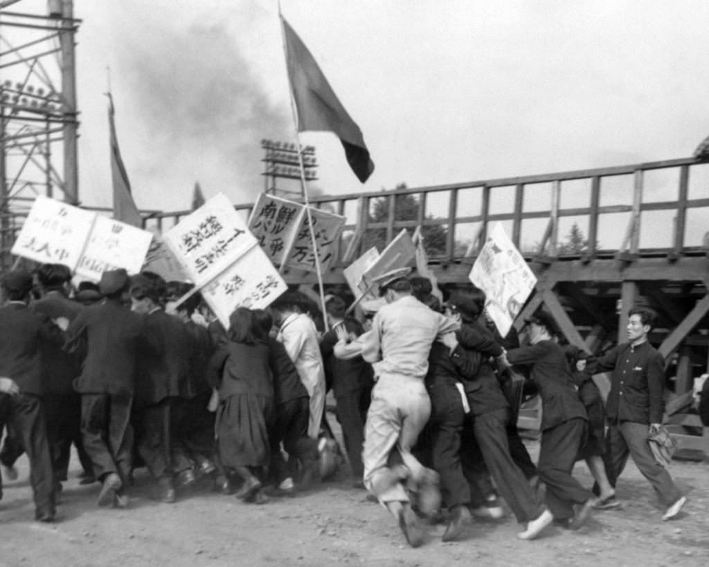#42 Students of the Red organized at the rally on the Imperial Palace Plaza in Tokyo on May 30, 1950, trying to rush some of the men sought by white helmet military policemen.