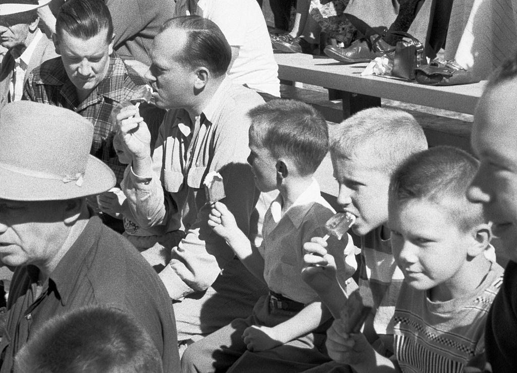 #46 Men and boys who eat ice cream during a Jaycee Little League baseball game between the Kinsmen and the Gyros at the Hillcrest Park, Vancouver, 1954.