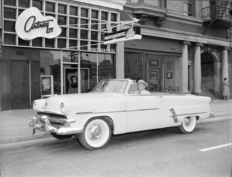 #51 Man in convertible parked outside Artray photograph Studios, ,781 Burrard Street, Vancouver, 1953