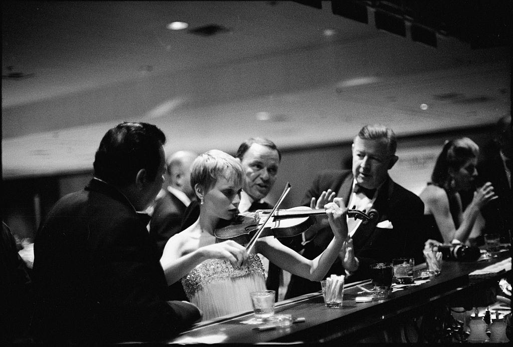 #69 Actress Mia Farrow and plays a violin, Las Vegas, 1966.
