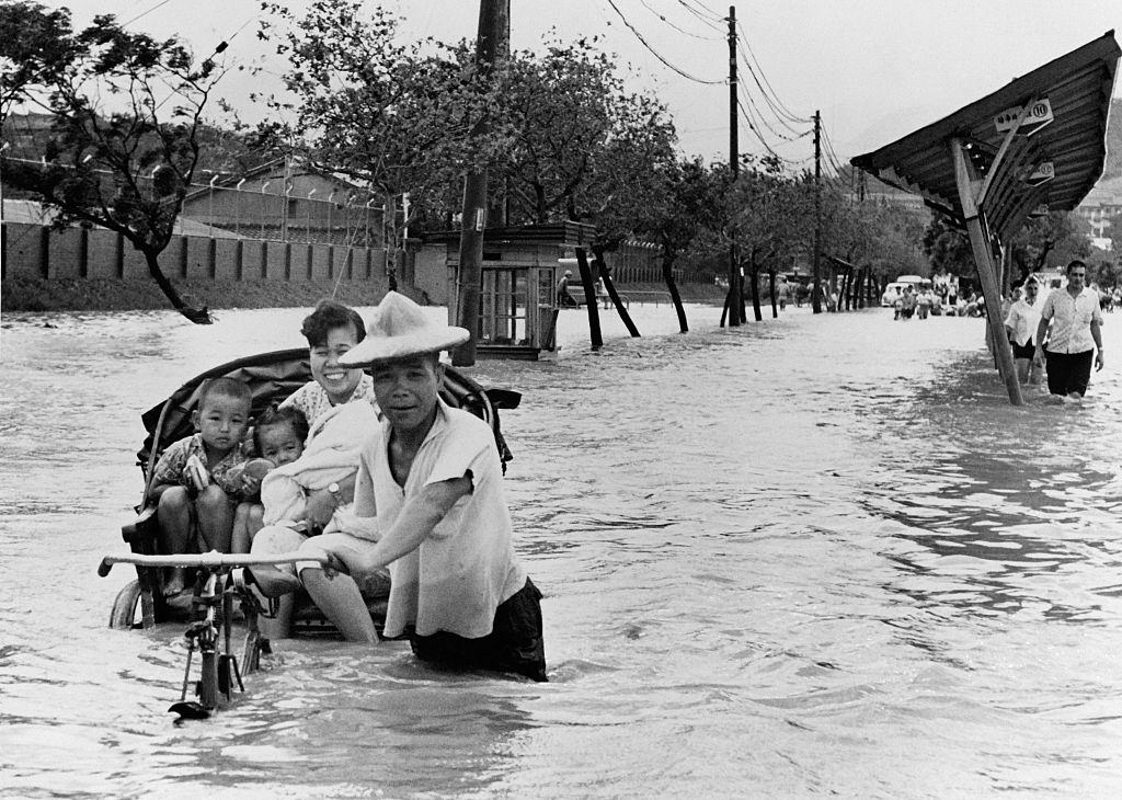 #18 A mother put her children in an Amphibiuous Rickshaw after the Floods, in Taipei, Taiwan, on September 15, 1962.