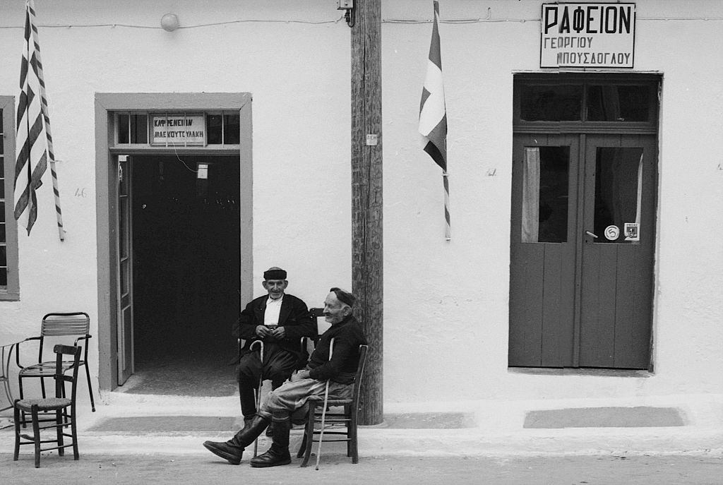 #30 Two old men sitting in the street in a Greek island. Greece, 1970s