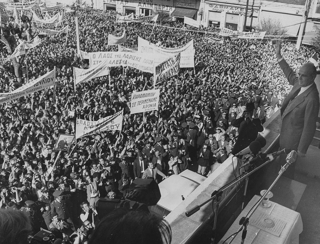 #39 Politician Andreas Papandreou waving from a balcony following the fall of the Greek military Junta, during a political rally, 1974.