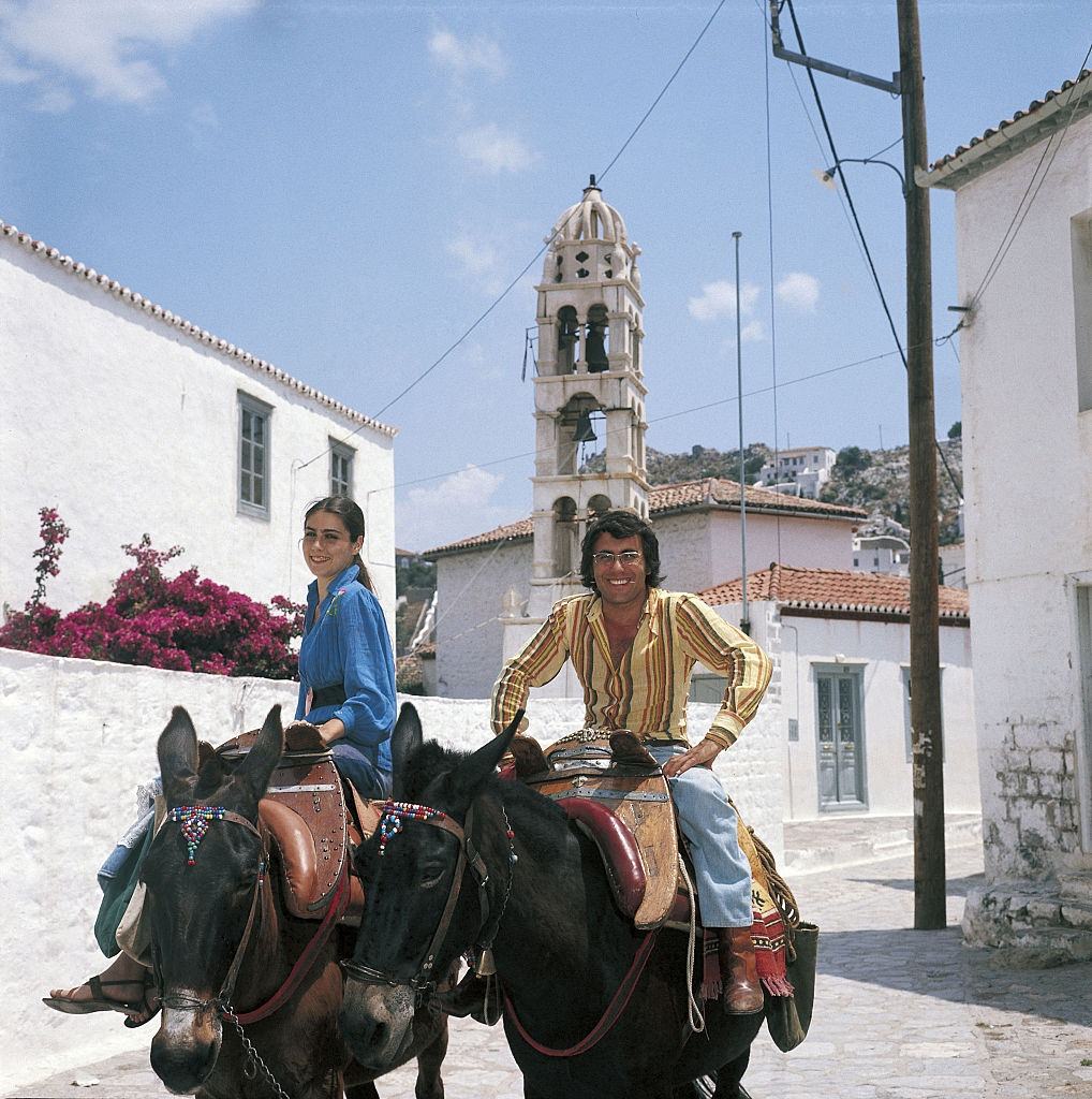 #54 The Italian singer Al Bano, born Albano Carrisi, smiles with his wife Romina Power riding a mule. Greece, 1975