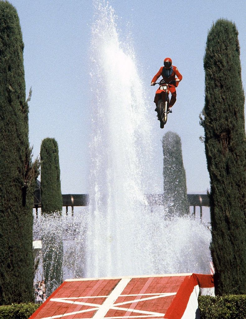 #16 American stunt driver Gary Wells jumps over the fountains outside the Caesar’s Palace casino on a motorcycle, Las Vegas, 1980.