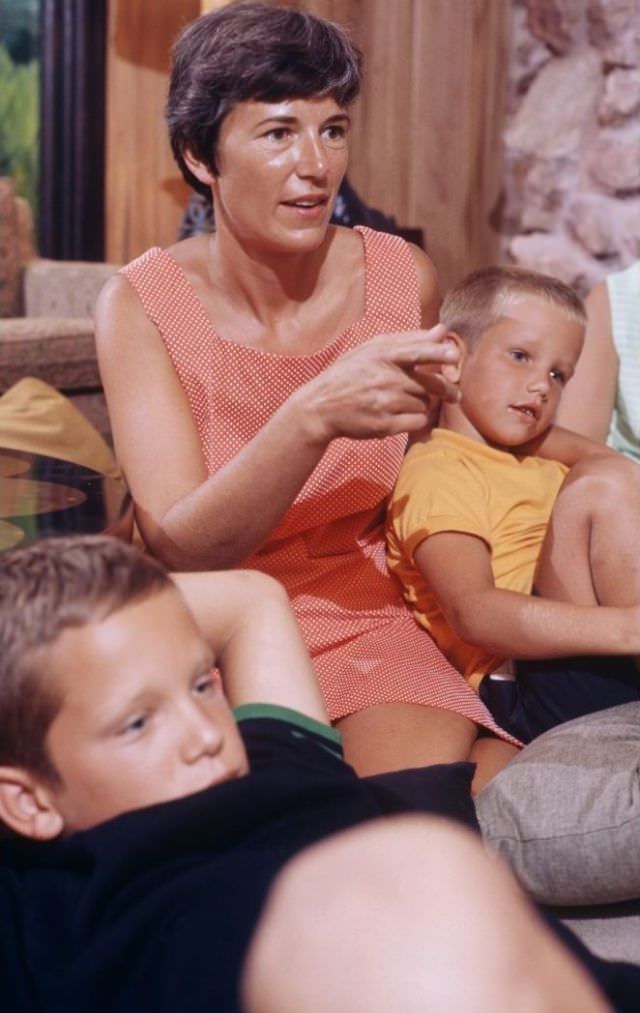 #6 Janet Armstrong sitting on floor with her two sons, attentively watching TV at home as the lunar module lands on the moon.