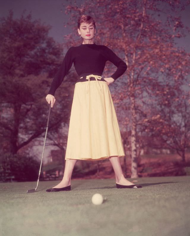 #15 Audrey Hepburn standing on a golf course, 1955.