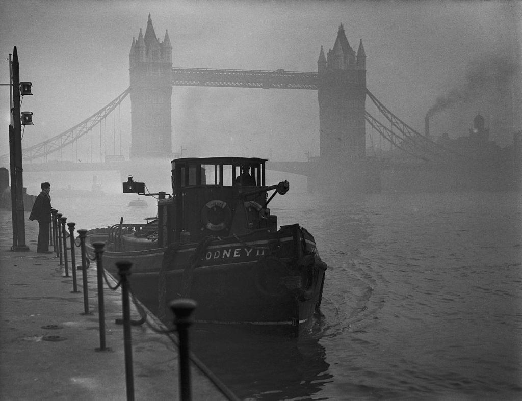#30 A tugboat on the Thames near Tower Bridge in heavy smog, 1952.
